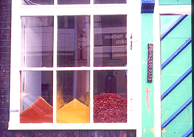 differently coloured spices piled up behind window